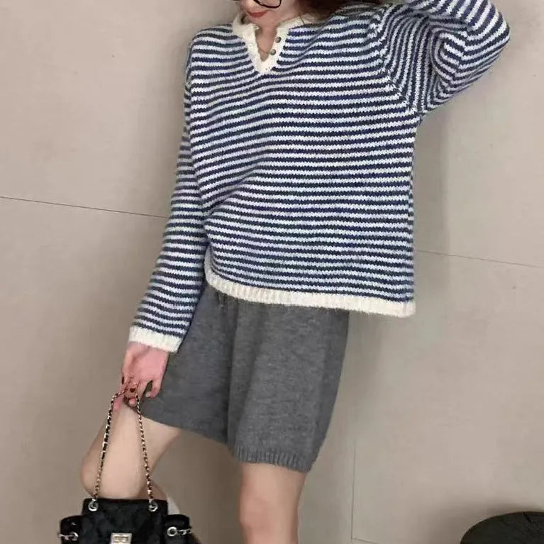 Woman wearing a loose red and blue striped cashmere pullover sweater with long sleeves.