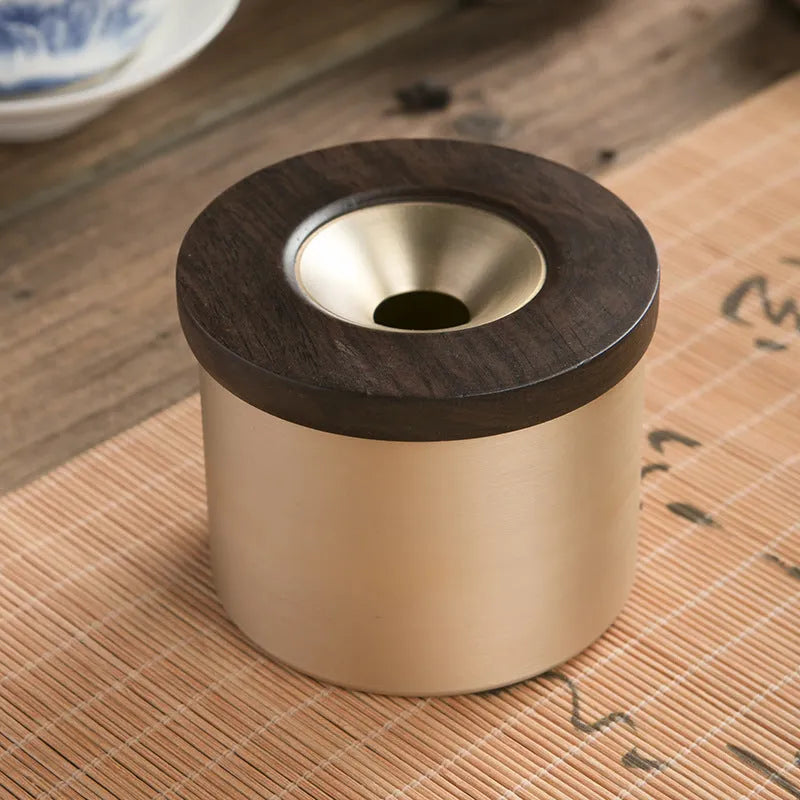 Retro brass ashtray with wooden lid showing centre hole design for ash collection