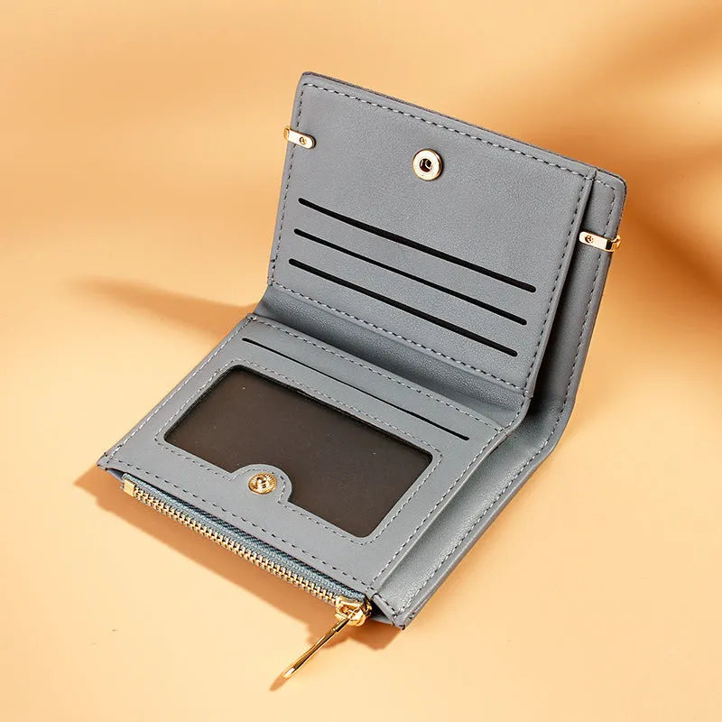 Black ladies short zipper wallet open to show multiple card slots, bill compartment, and change slot.