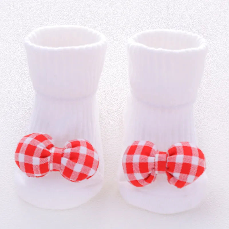 Cotton baby floor socks with non-slip soles in a pink bow print design.