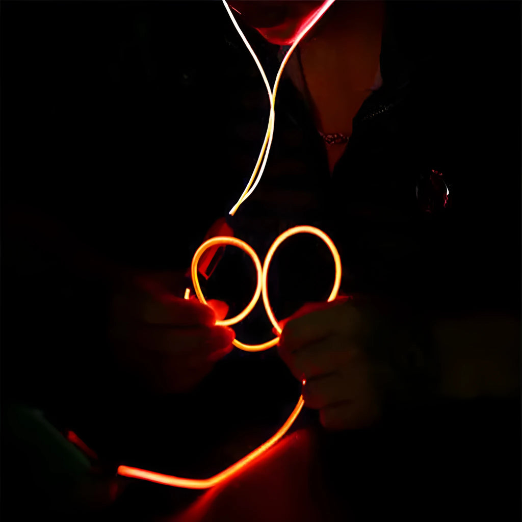 Blue Magic Light LED earphones with glowing stems, 3.5mm plug, and inline remote on a dark background.