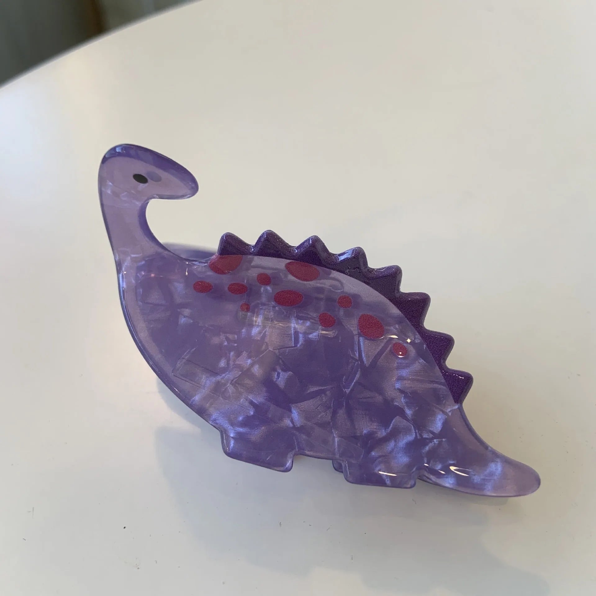 Dinosaur-themed acrylic jaw hair clip showing detailed dinosaur design and secure grip mechanism