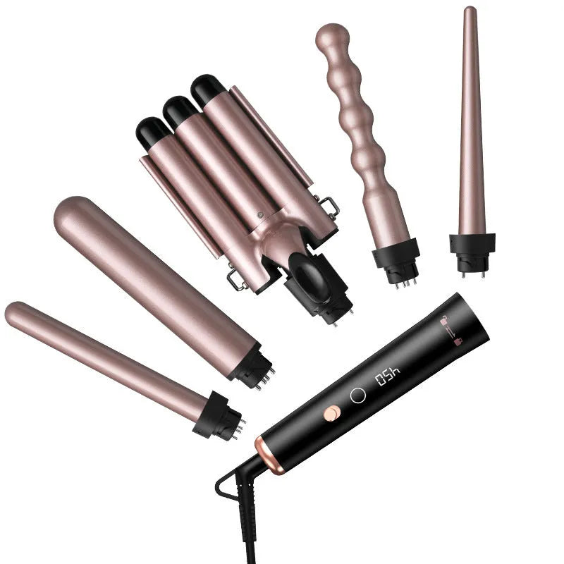 Rose gold hair curler with LCD display, replacement tubes, and heat-resistant gloves on a table.