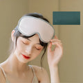 Pink or green portable steam sleep massage goggles with USB cable on a grey background.