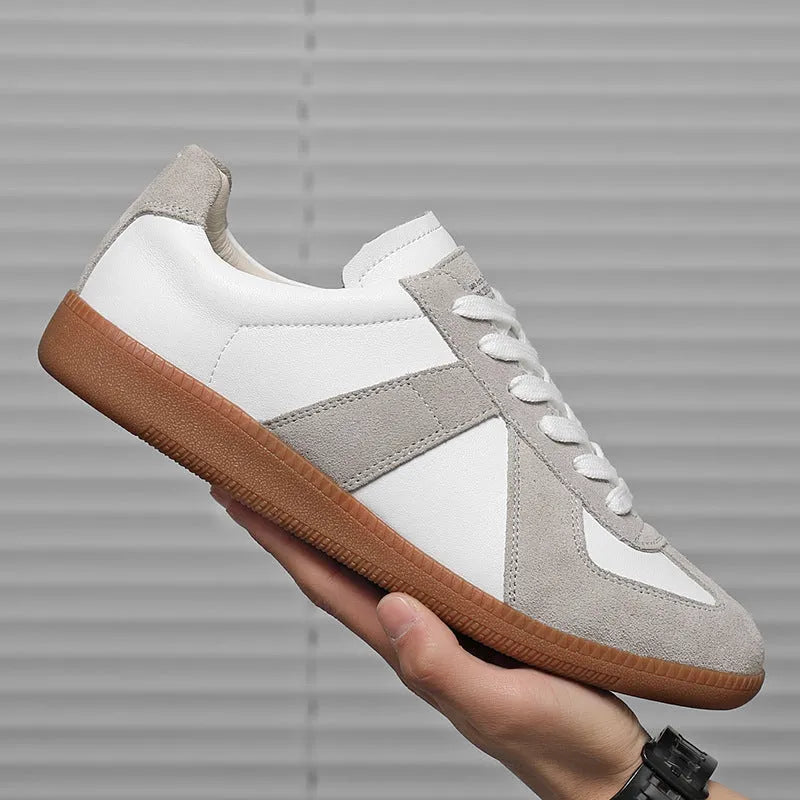Men's low top white retro sneakers with round toe and flat rubber sole on a plain background