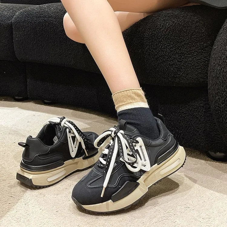 Women's black retro platform sports shoes with round toe and white rubber sole on a plain background.