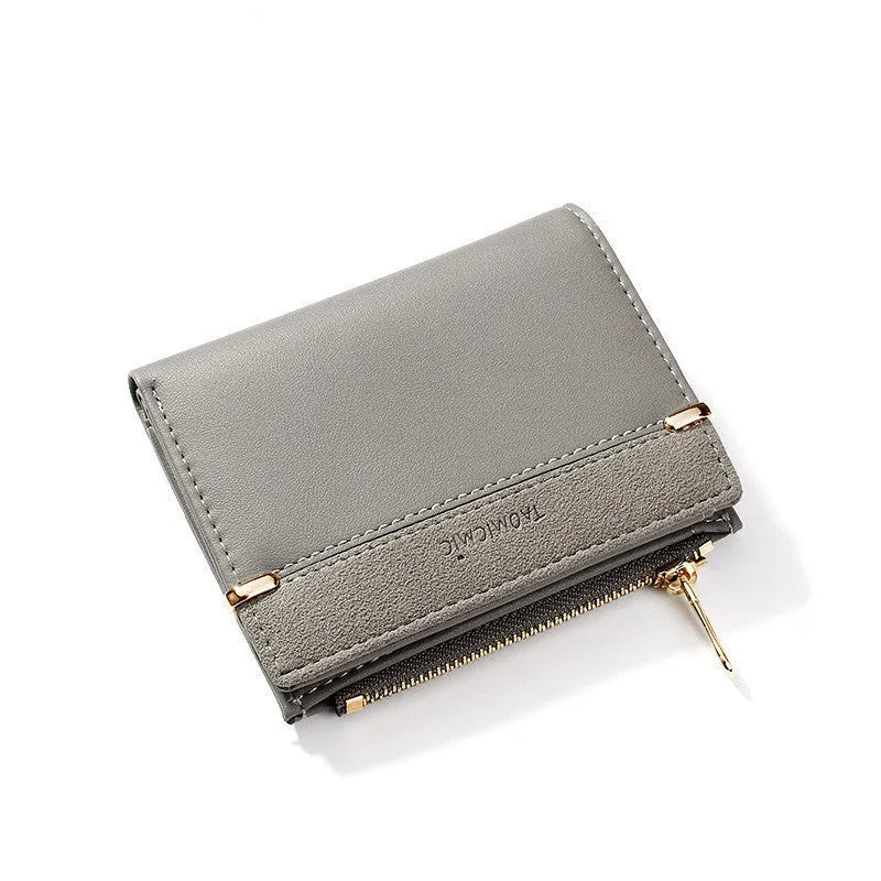 Black ladies short zipper wallet open to show multiple card slots, bill compartment, and change slot.