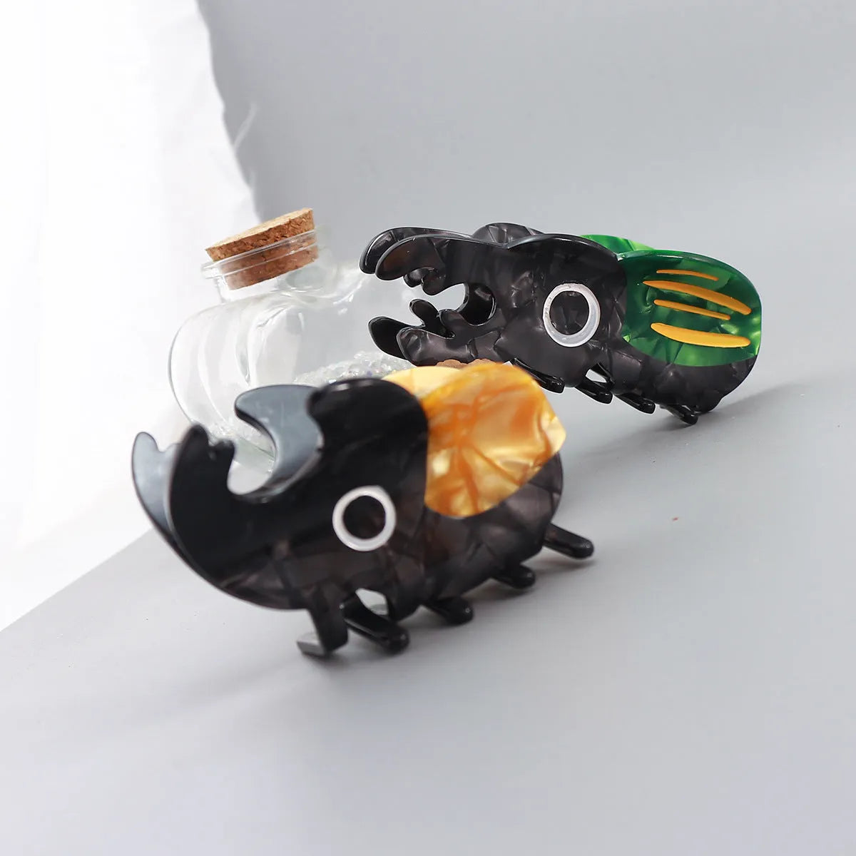 Handmade cellulose acetate beetle grip showing green beetle, orange beetle, and white caterpillar colour variants