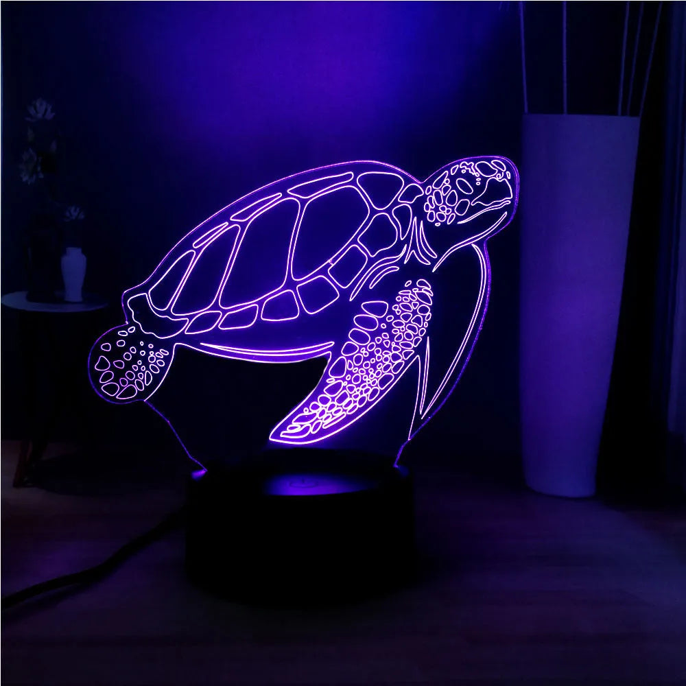 3D acrylic turtle-shaped LED night light with multi-colour glow on a surface.