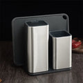 Black and white kitchen knife holder with storage bucket and detachable base on a countertop.