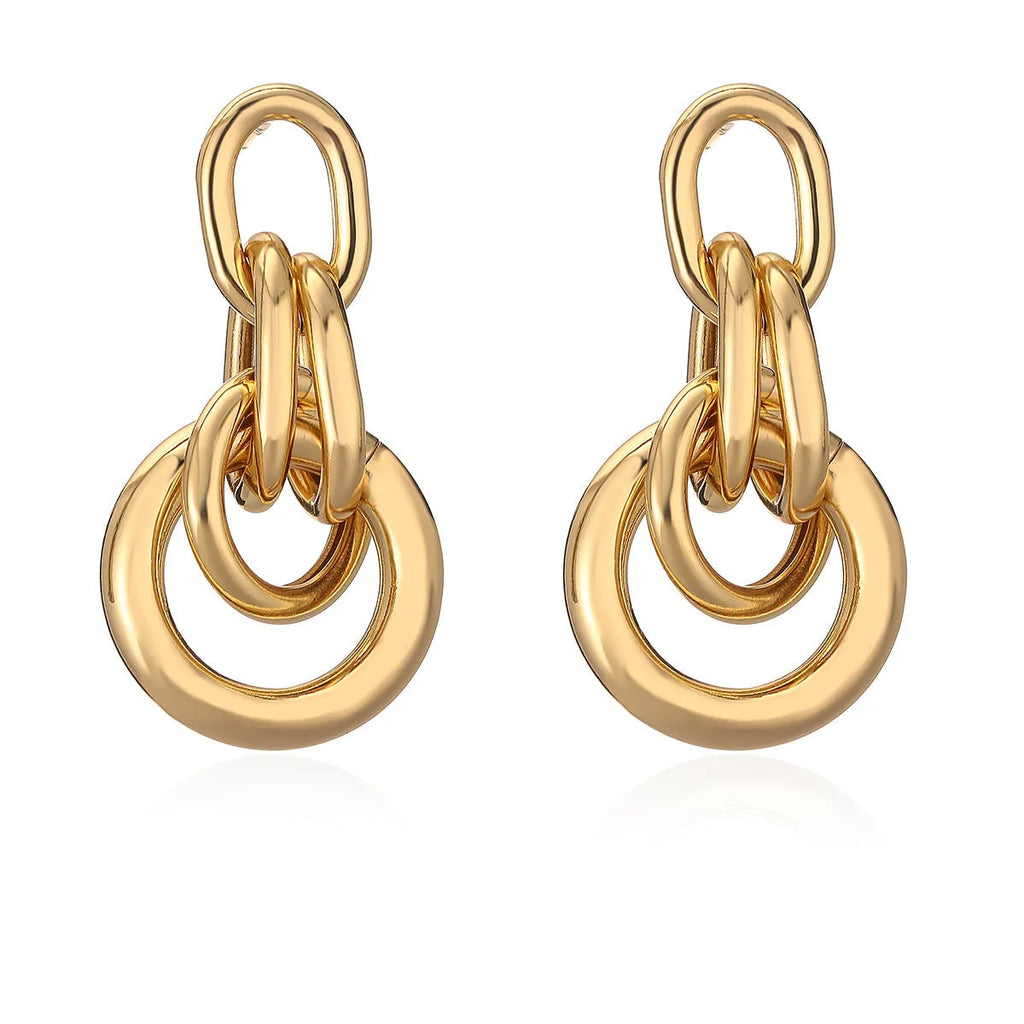 Geometric gold drop earrings with an irregular shape on a copper base.