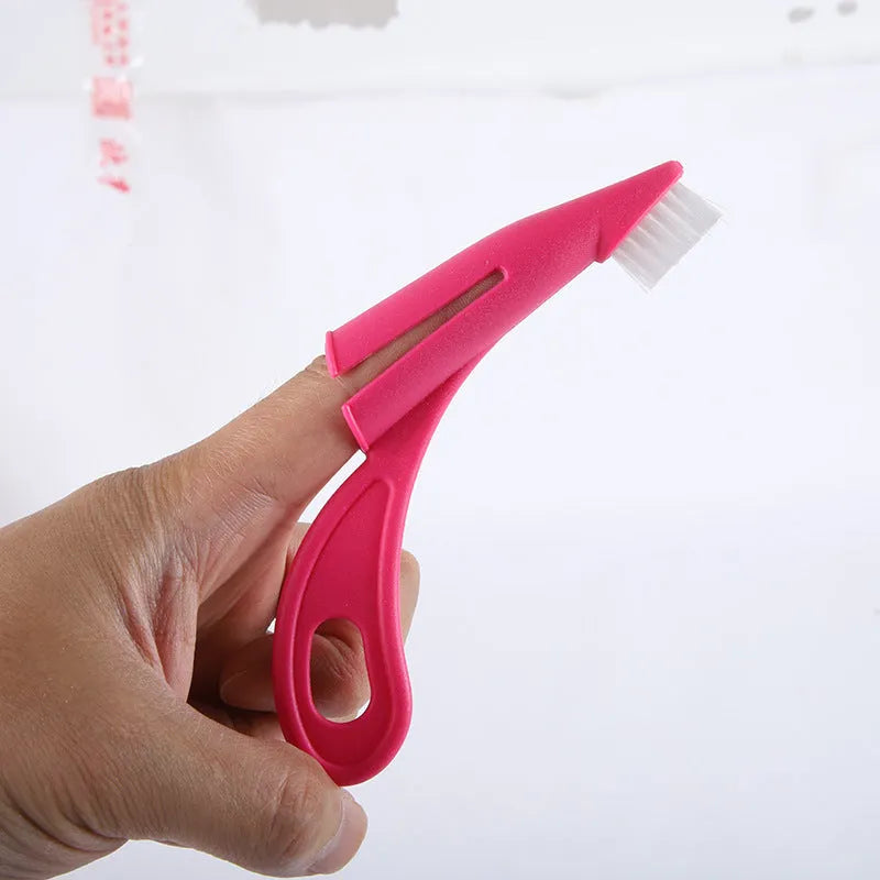 Red and white finger sleeve toothbrush for cleaning dog and cat teeth with soft silicone bristles.