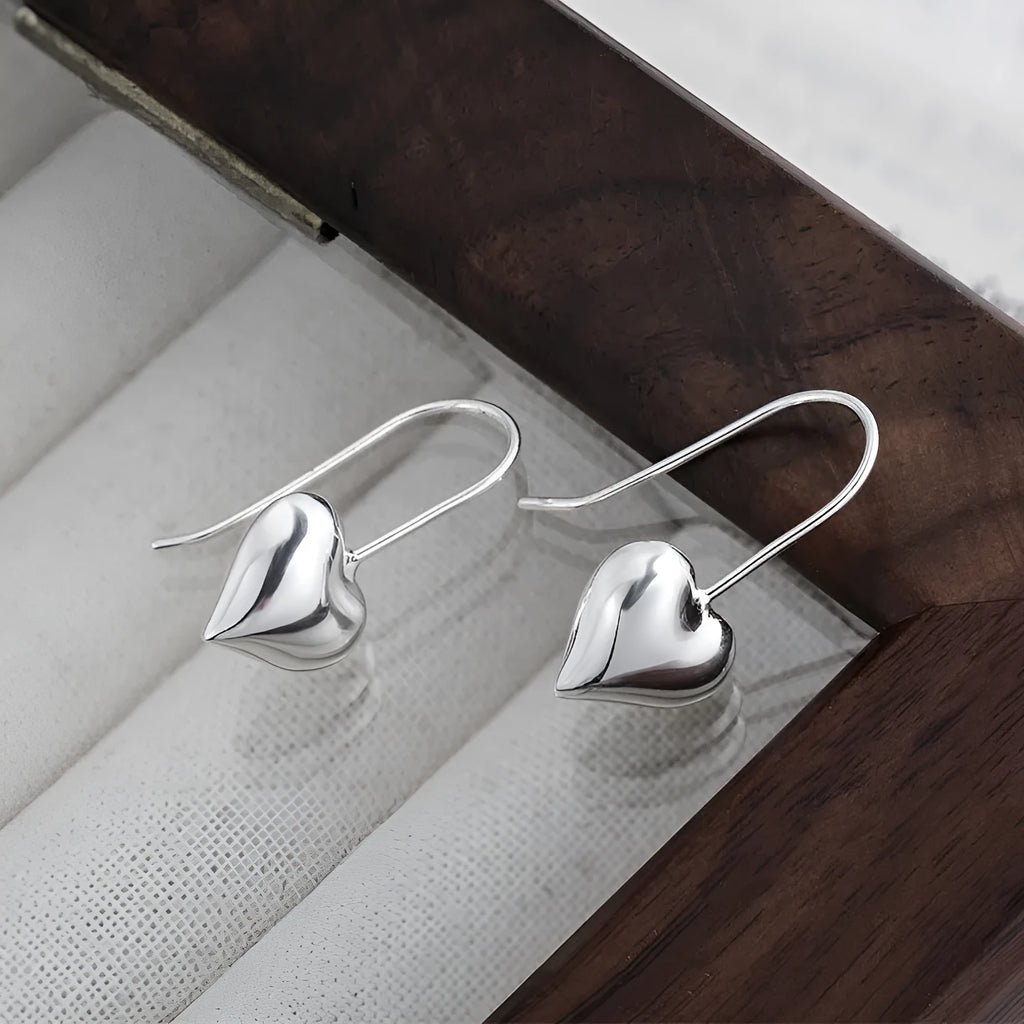 Korean style silver-coloured heart earrings with three-dimensional glossy finish and matching heart-shaped ear hooks