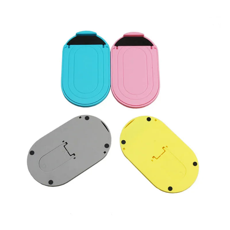 Plastic adjustable bracket mobile phone stand in six colour choices on a desk.