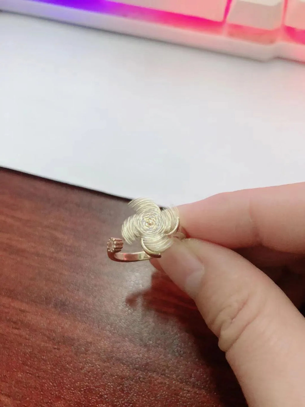 Gold and silver rotating ring with micro-inlaid geometric design on a copper band.