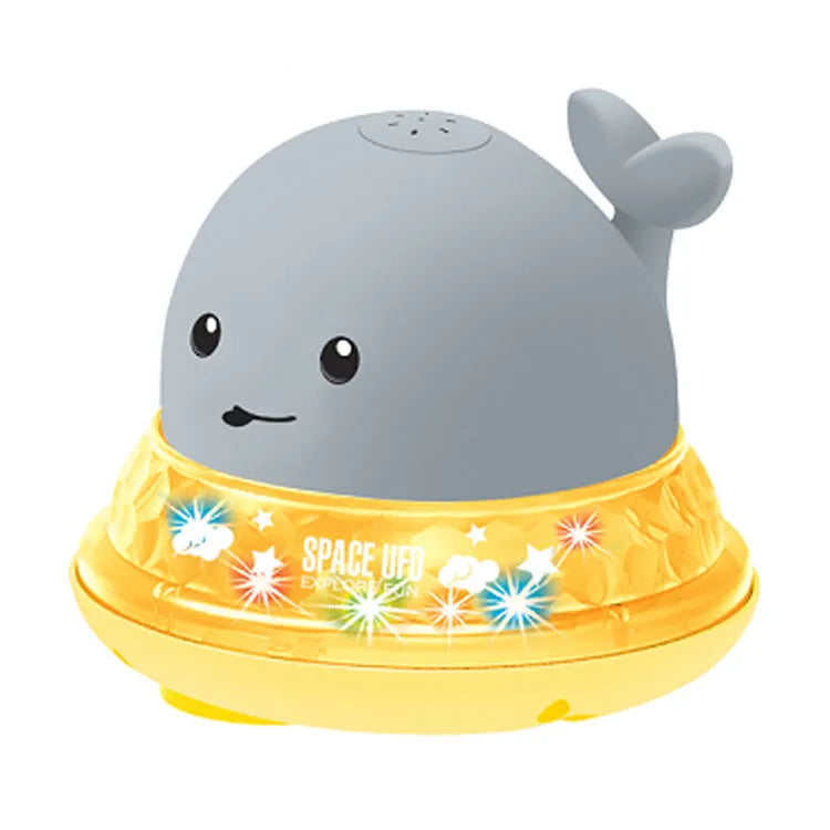 Whale-shaped baby bath toy with automatic water spray and colourful lights floating in water.