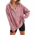 Women's loose-fitting peacock green pullover sweater with raglan long sleeves on a hanger.