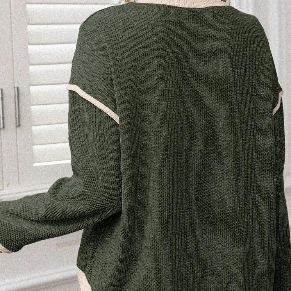 Women's beige loose knit top with green four leaf clover contrast trim on the V-neck and long sleeves.