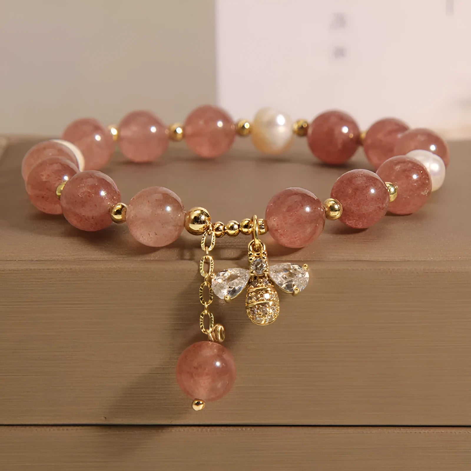 Women's bracelet with freshwater pearls, pink strawberry quartz stones, and a metallic zircon alloy clasp.