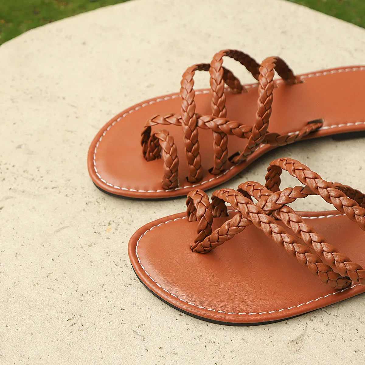 Women's white woven clip-toe flat sandals with a rubber sole on a neutral background.