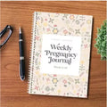 A5 pregnancy weekly diary notebook open showing weekly pregnancy tracking pages