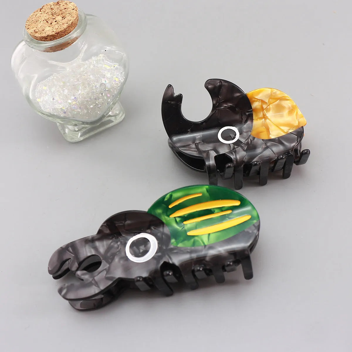 Handmade cellulose acetate beetle grip showing green beetle, orange beetle, and white caterpillar colour variants