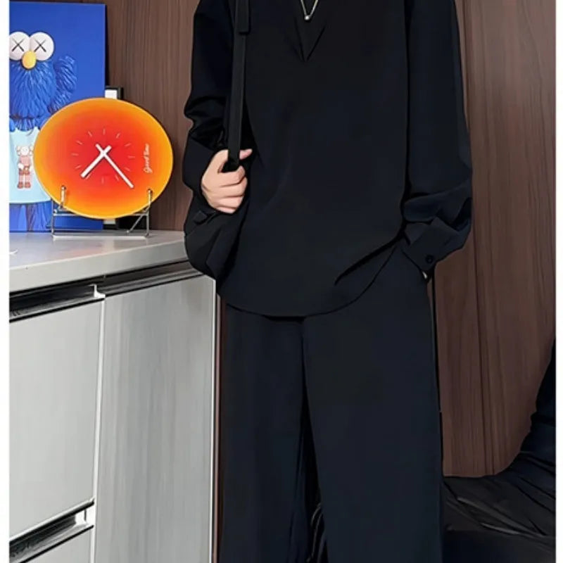 Man wearing a black slim fit long sleeve polo shirt and matching trousers from a casual two-piece set.