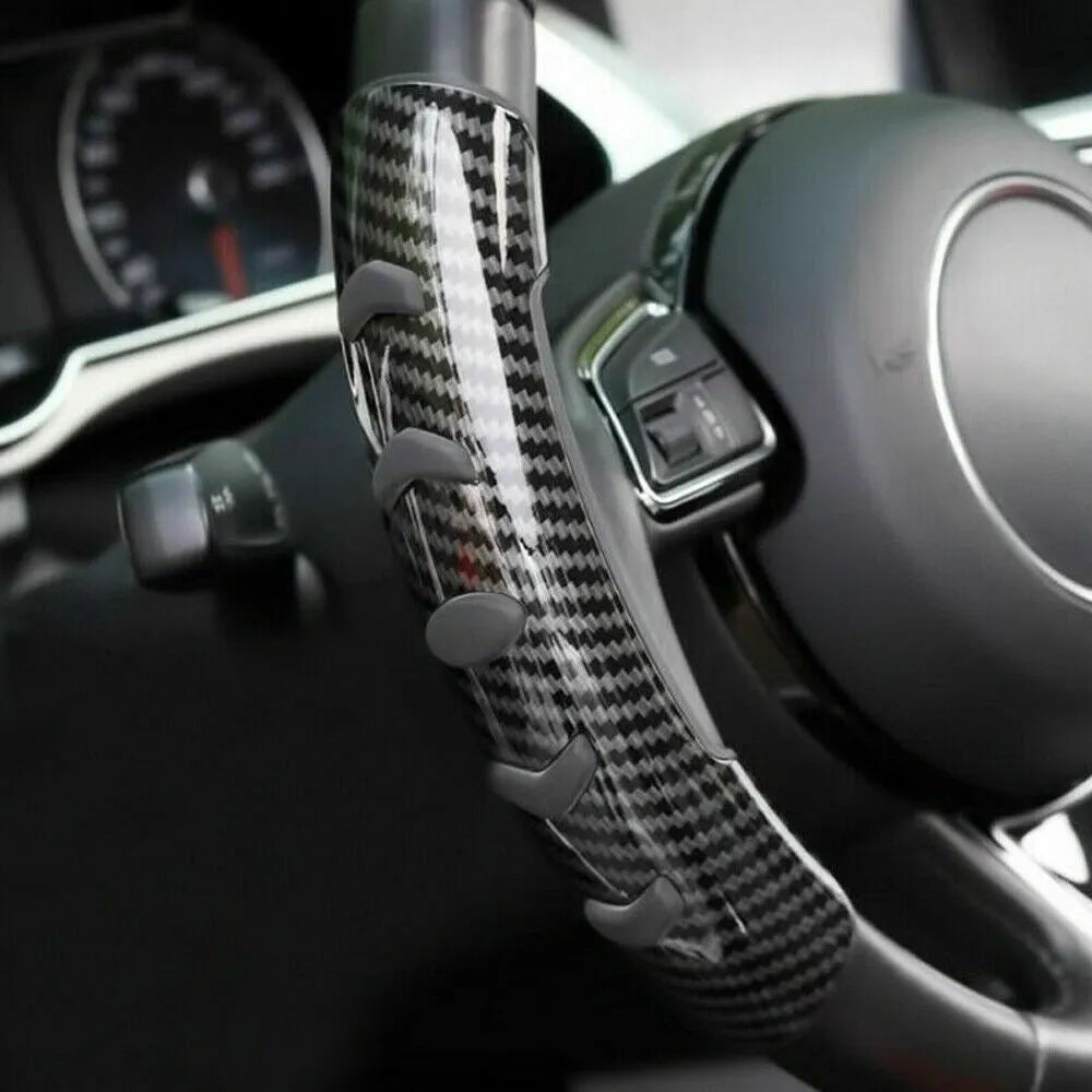 Carbon fibre black fibre anti-skid sleeve on a car steering wheel.