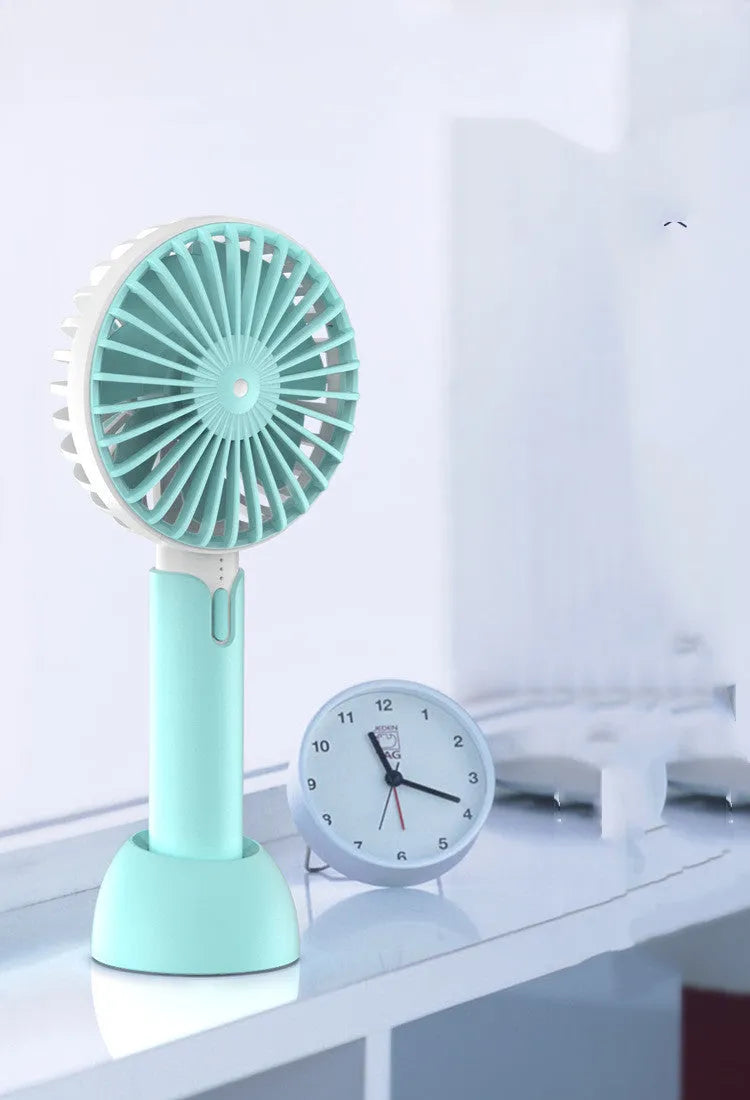 Blue handheld mini silent desktop USB electric fan with oscillating head on a desk