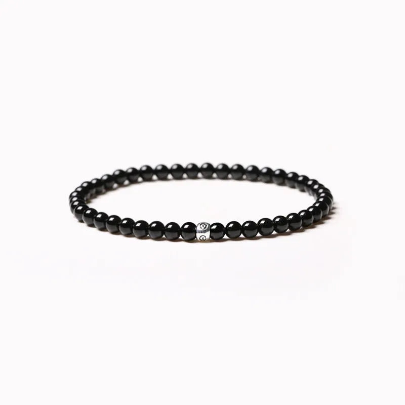 A unisex geometric bracelet with round and square obsidian, blue San and agate beads on a black background.