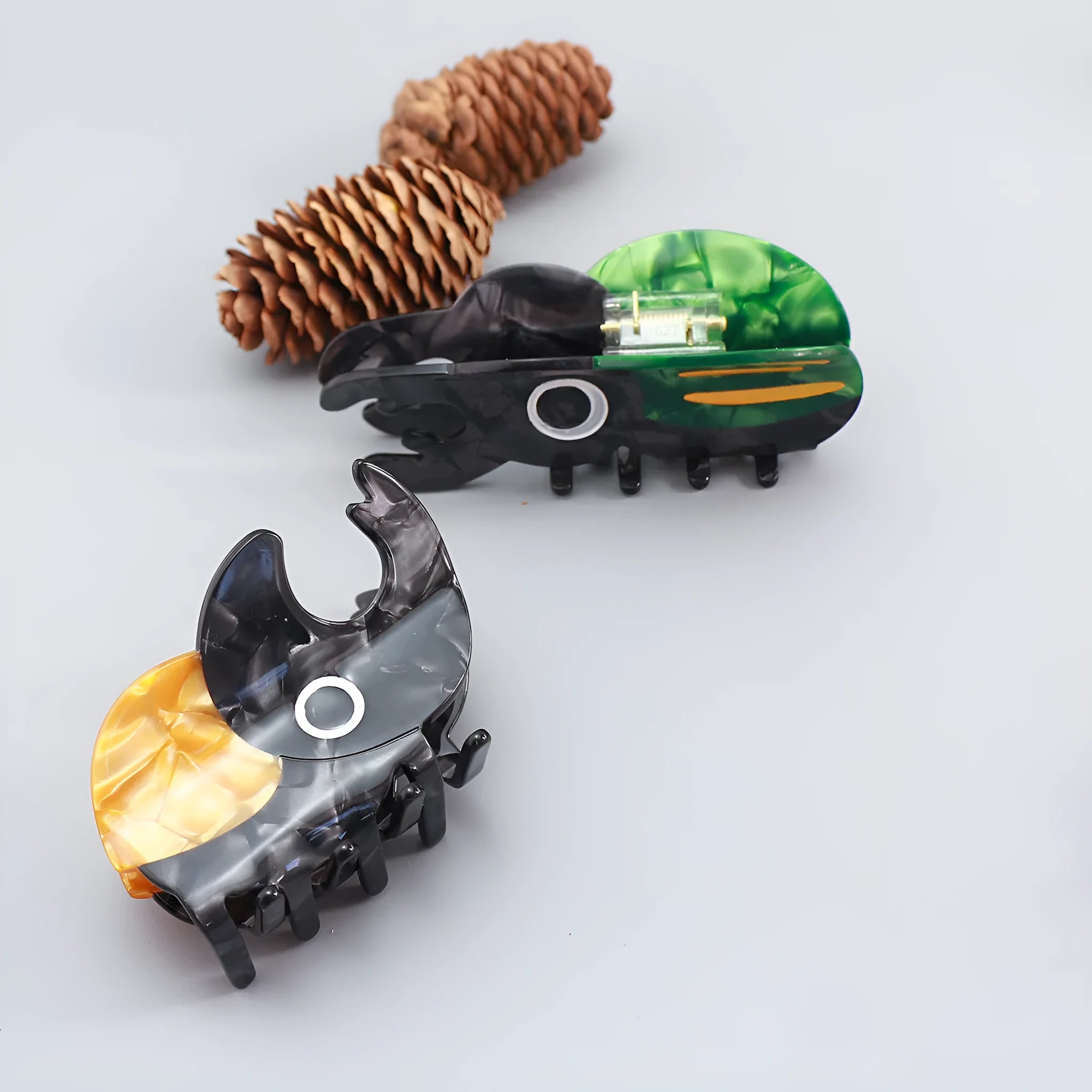 Handmade cellulose acetate beetle grip showing green beetle, orange beetle, and white caterpillar colour variants