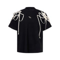 Black loose fit T-shirt with padded shoulder detail and rivet ribbon accent.