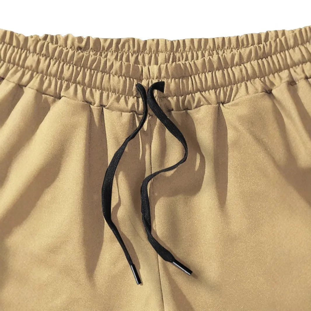 Khaki men's sports shorts with a white coconut leaf print, showing a straight leg and short length.
