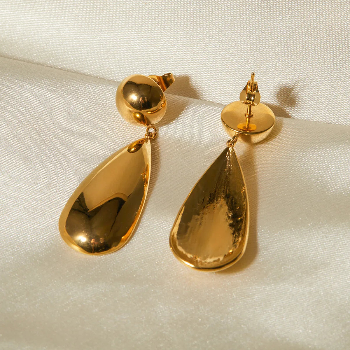 Gold electroplated stainless steel water drop pendant earrings with geometric hemisphere shapes