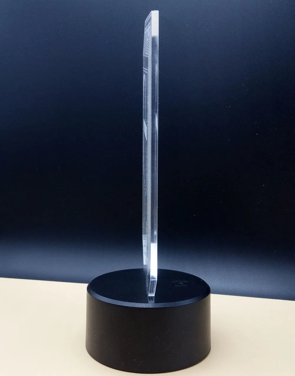 A 3D acrylic rose LED night light with a black base, displaying a purple glow, sitting on a wooden surface.