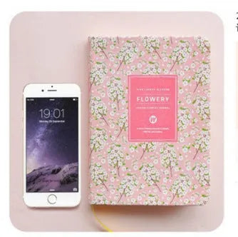 Green floral pattern notepad with fabric leather cover showing wireless binding and open pages