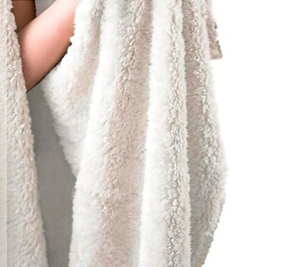 Coral coloured round flannel burrito blanket on a grey background