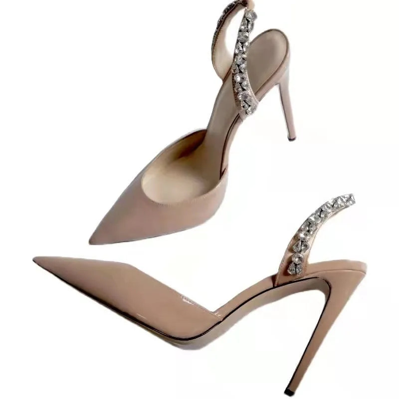 Women's black patent leather pointed toe high heel sandals with side rhinestones and an ankle strap.