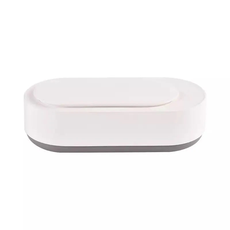 White portable ultrasonic cleaner with stainless steel tank and a single control button.