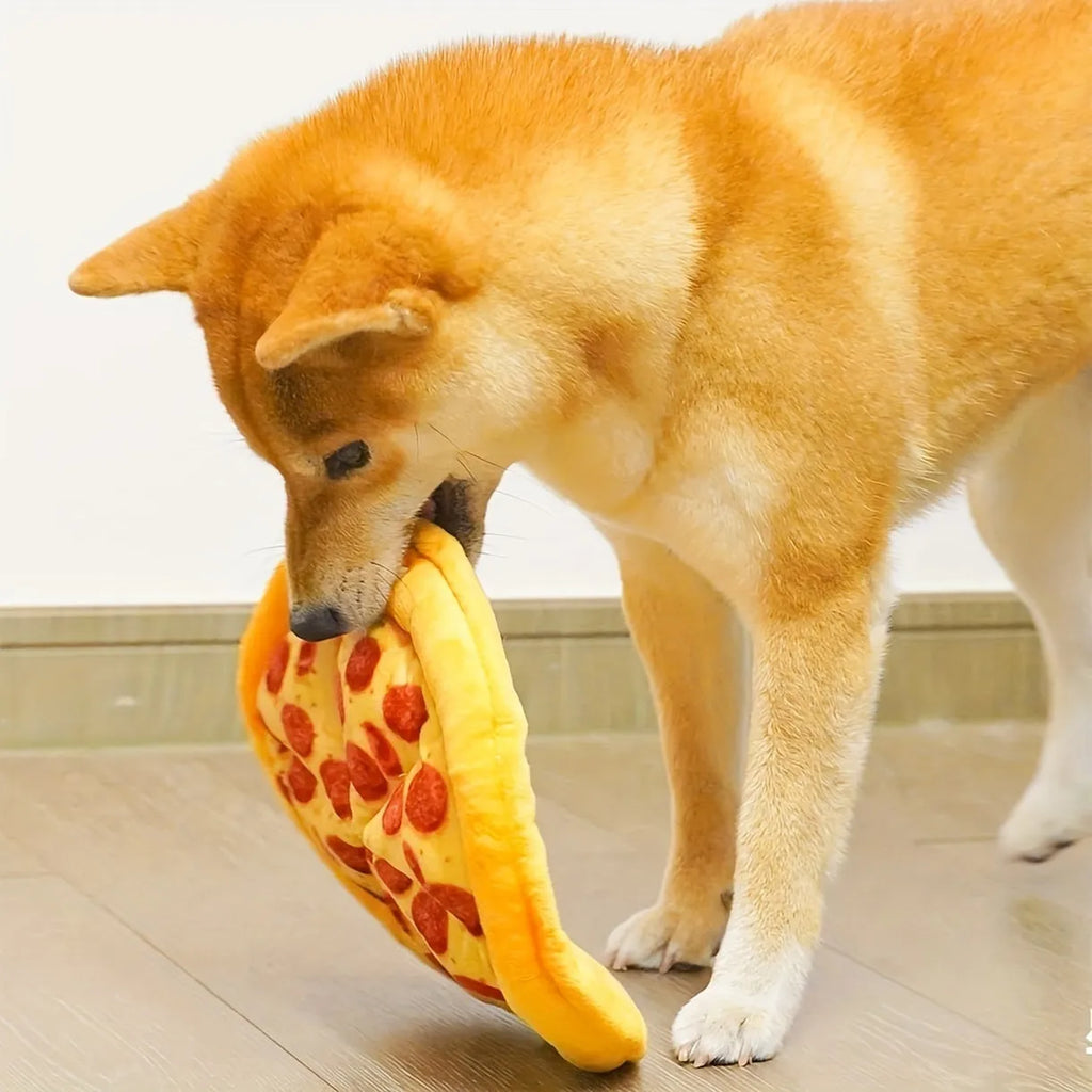 Yellow pizza slice shaped soft plush dog chew toy with squeaker on a white background.