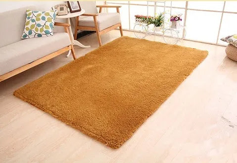 Solid colour fluffy plush carpet with non-slip dots on bottom, shown in beige on a wooden floor.