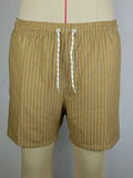 Man wearing grey striped polyester beach shorts with a straight leg opening