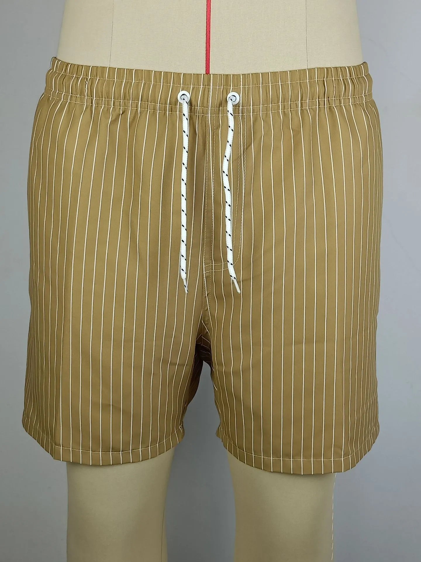 Man wearing grey striped polyester beach shorts with a straight leg opening