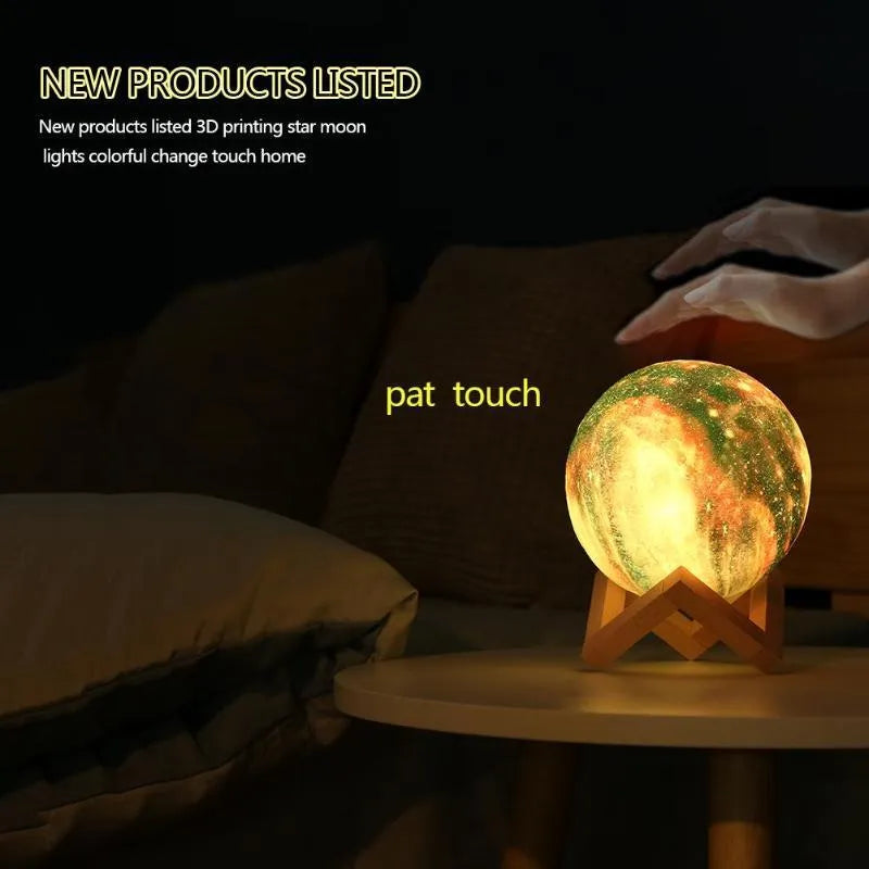 3D printed spherical lunar surface night light glowing with soft yellow and white LED light on a table.