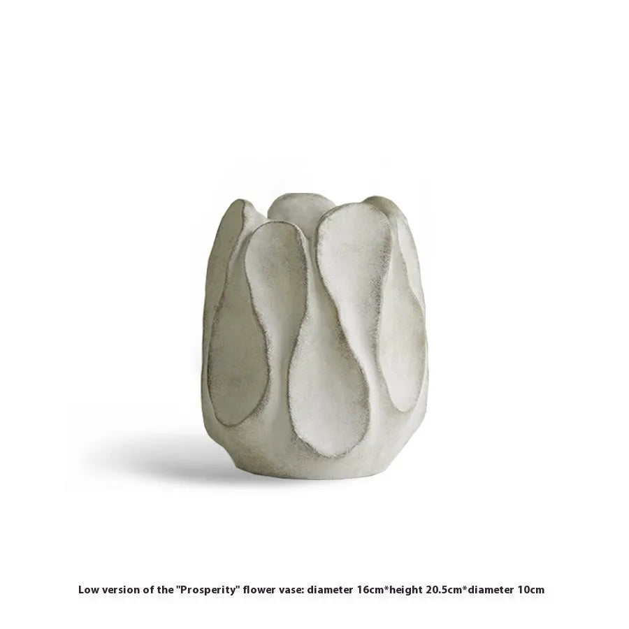 Irregular shaped handcrafted ceramic vase on a wooden surface, showing its artisanal form.