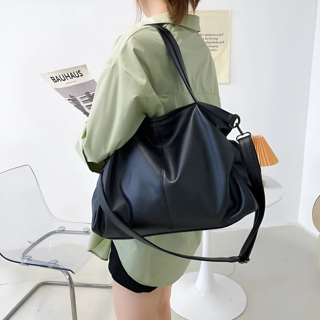 Large horizontal square soft-surface PU leather messenger bag with a long shoulder strap and zip opening.