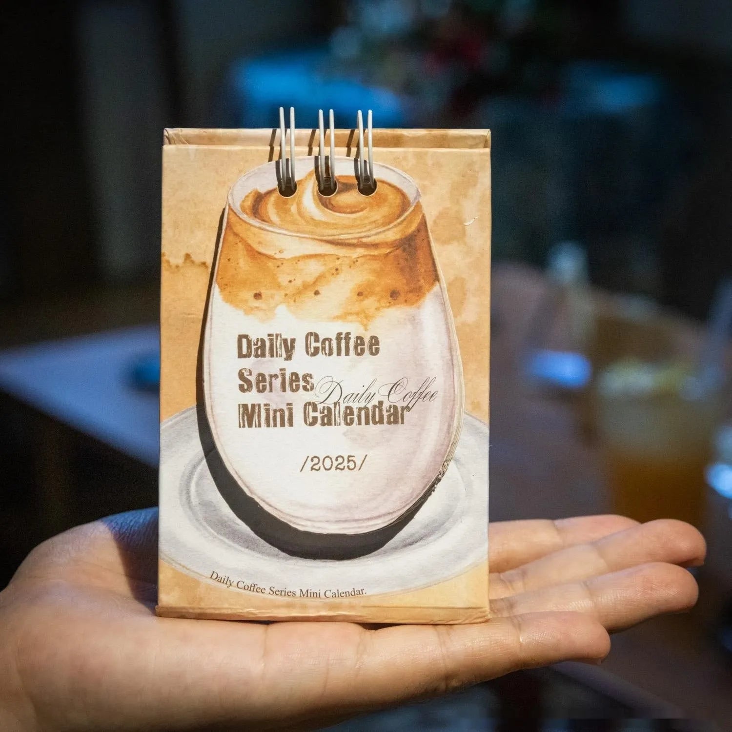 Mini coffee desk calendar 2025 with four design options on small desk surface