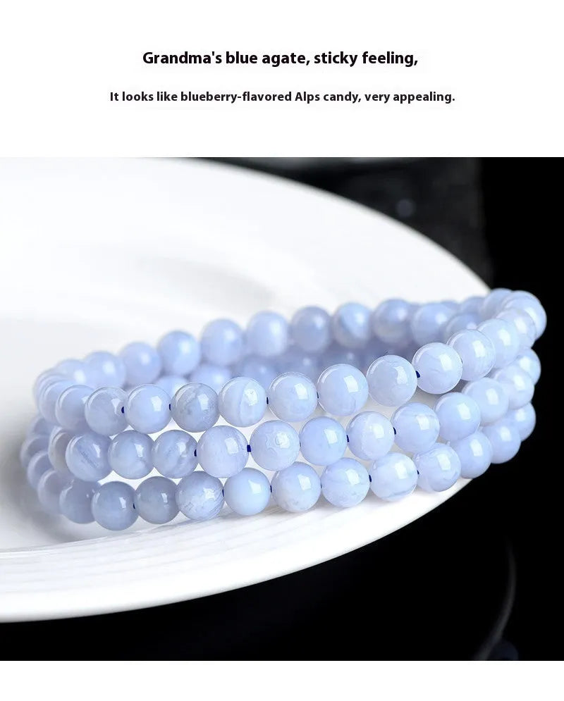 Blue agate bracelet with scattered multi-circle stripes and Ruyi design on wrist.
