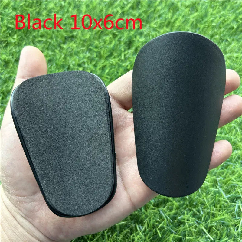 Pair of extra small black plastic football shin guards for junior players.