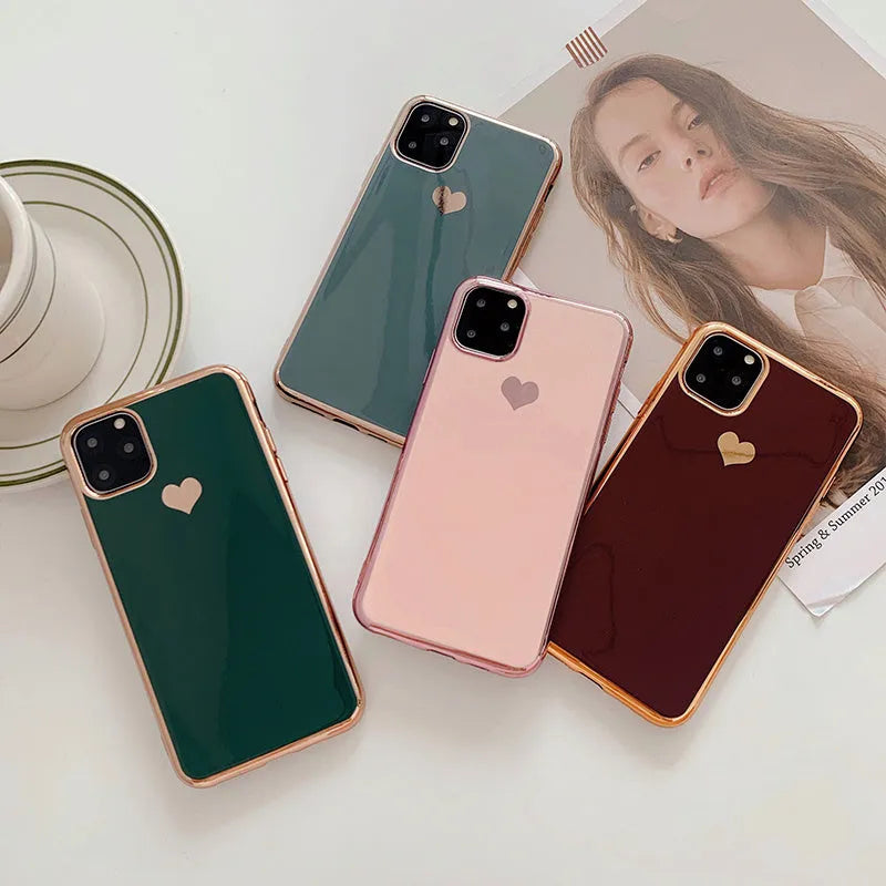 Solid colour TPU back cover case for iPhone on a table, shown in blue, claret, pink, and green.